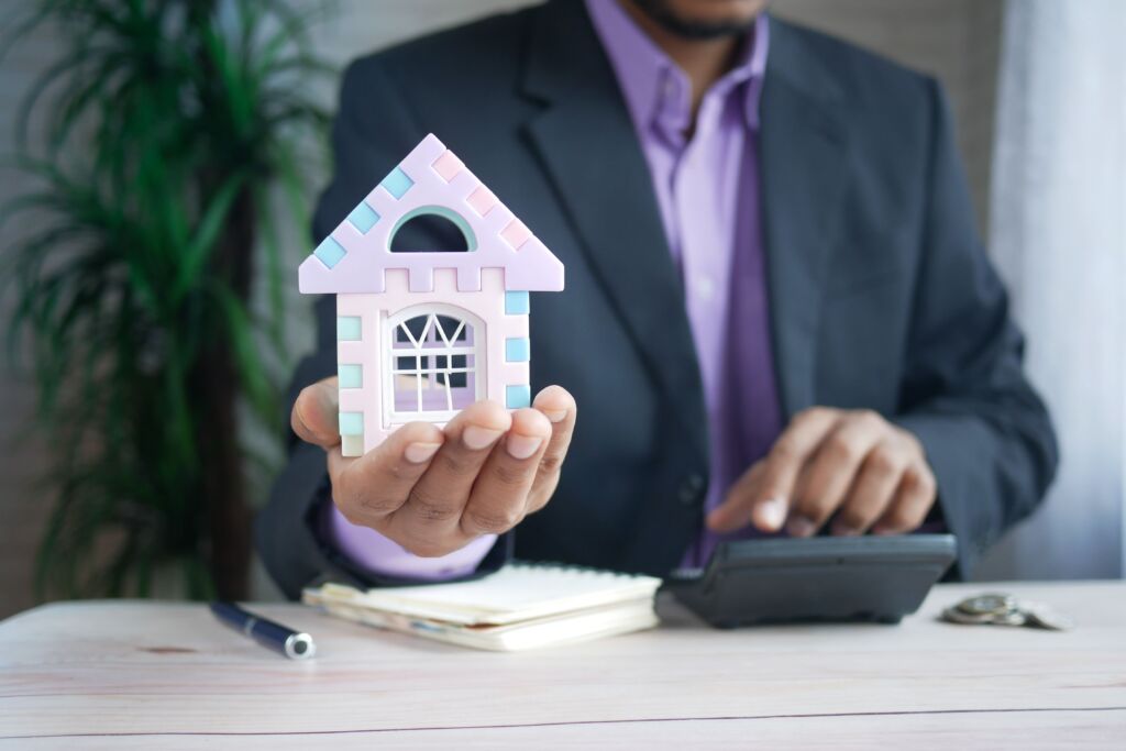 man holding mini house model
